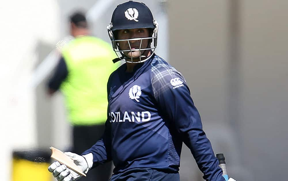 Scotland batsman Majid Haq holds a piece of his broken bat during their Cricket World Cup Pool A match against Afghanistan in Dunedin, New Zealand.