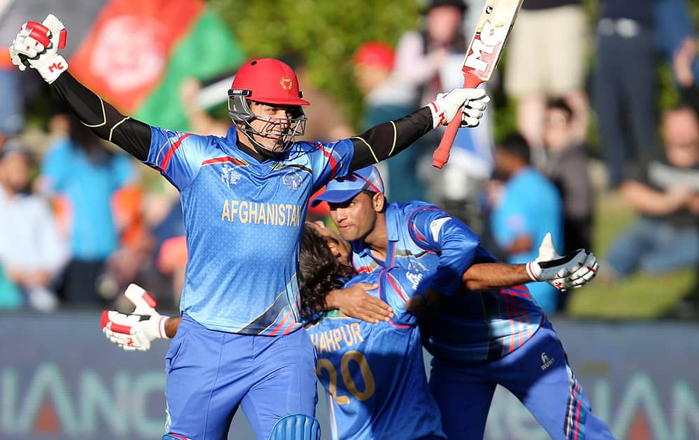 Afghanistan’s Hamid Hassan raises his bat in celebration after their Cricket World Cup Pool A win over Scotland in Dunedin, New Zealand.