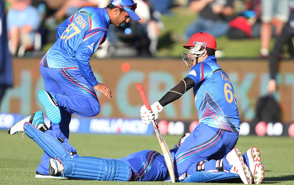 Afghanistan’s Hamid Hassan and teammate's Shapoor Zadran and Usman Ghani celebrate their Cricket World Cup Pool A win over Scotland in Dunedin, New Zealand.