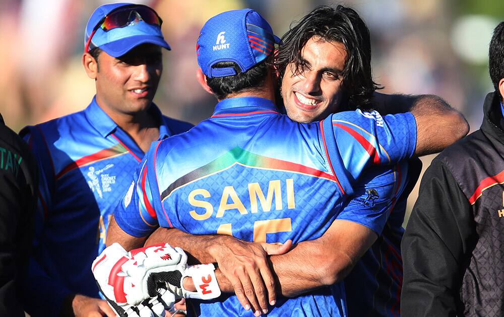 Afghanistan’s Shapoor Zadran embraces teammate Samiullah Shenwari as he celebrates his team's Cricket World Cup Pool A win over Scotland in Dunedin, New Zealand.