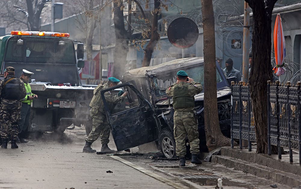 Turkish soldiers inspect a damaged vehicle at the site of a suicide attack in Kabul, Afghanistan. A suicide bomber driving a car packed with explosives targeted a Turkish Embassy vehicle near the Iranian Embassy in the Afghan capital during the Thursday morning rush hour.