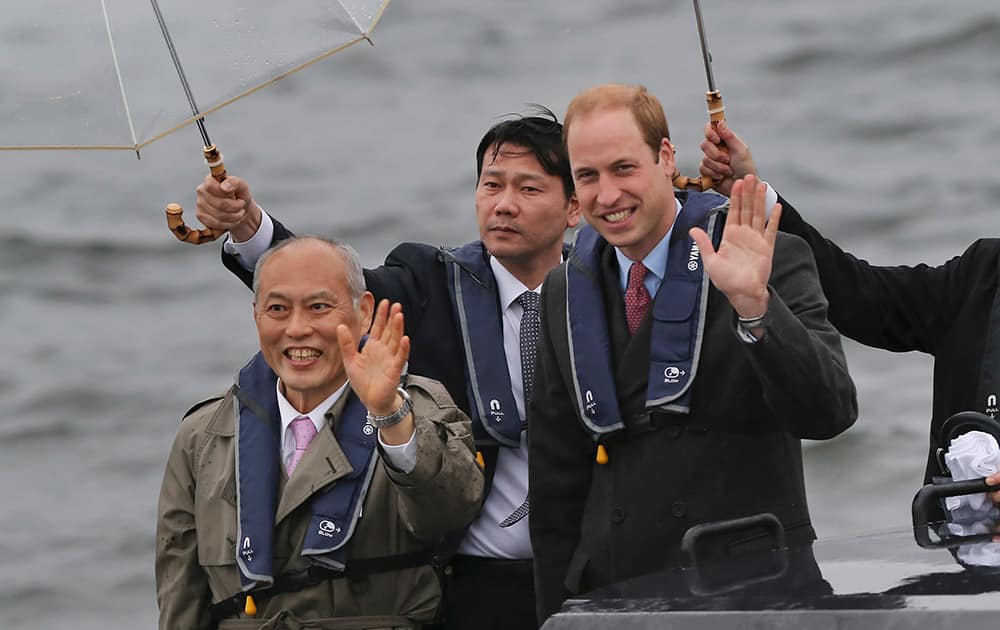 Britain's Prince William, waves with Tokyo Gov. Yoichi Masuzoe from a boat in Tokyo harbor after arriving in Tokyo. The Duke of Cambridge is on a four-day visit to Japan.