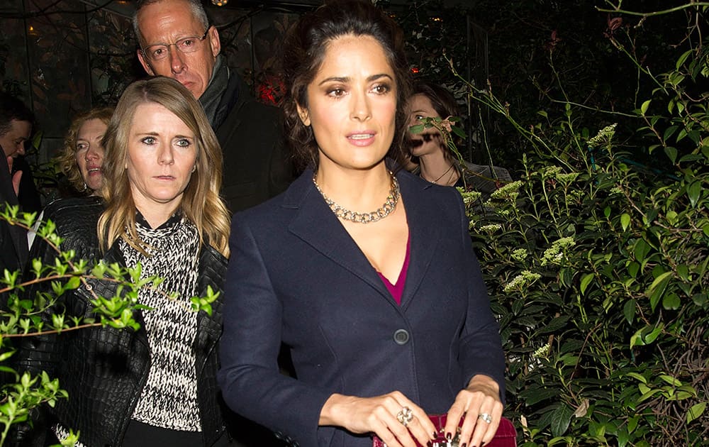 Mexican actress Salma Hayek, right, arrives at a Pomellato party during the Milan Fashion Week.