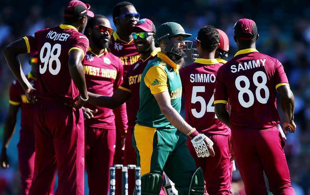 South Africa's Hashim Amla walks from the field as West Indies players celebrate his dismissal during their Cricket World Cup Pool B match in Sydney, Australia.