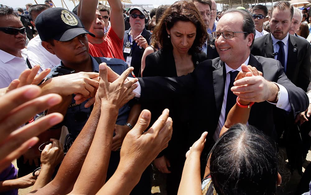 French President Francois Hollande, front right, is greeted by the crowd during his visit to the typhoon-ravaged Guiuan township, Eastern Samar province in central Philippines.