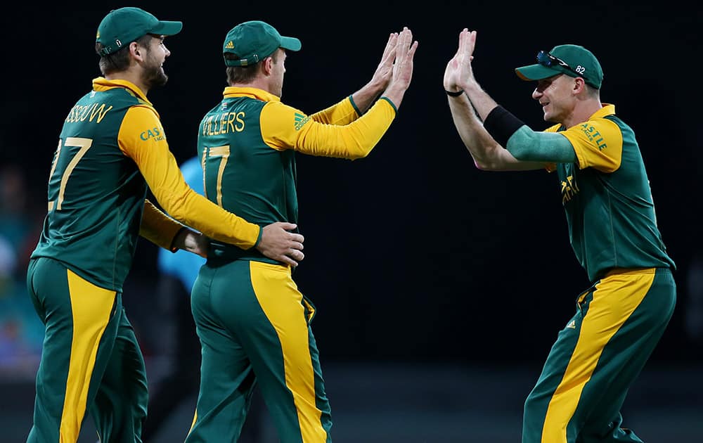 South Africa's AB De Villiers is congratulated by teammates Dale Steyn and Rilee Rossouw after taking a catch to dismiss West Indies Jonathan Carter during their Cricket World Cup Pool B match in Sydney, Australia.