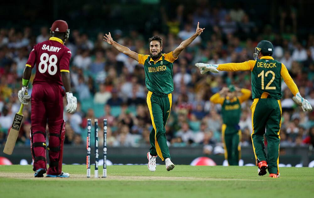 South Africa's Muhammad Imran Tahir celebrates with teammate Quinton De Kock after West Indies Darren Sammy was stumped five runs during their Cricket World Cup Pool B match in Sydney, Australia.