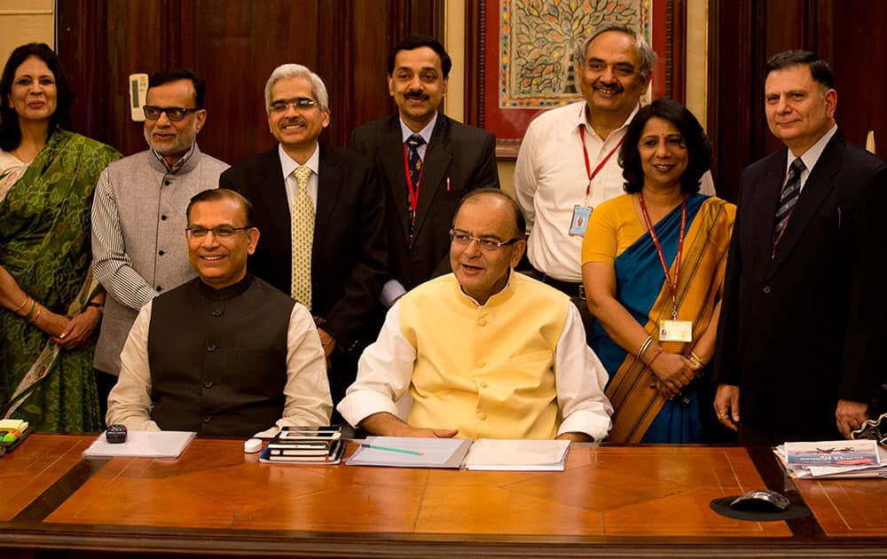 Indian Finance Minister Arun Jaitley, and Indian Minister of State for Finance Jayant Sinha, pose for photographs with their team on the eve of annual budget presentation, in New Delhi, India, Friday.