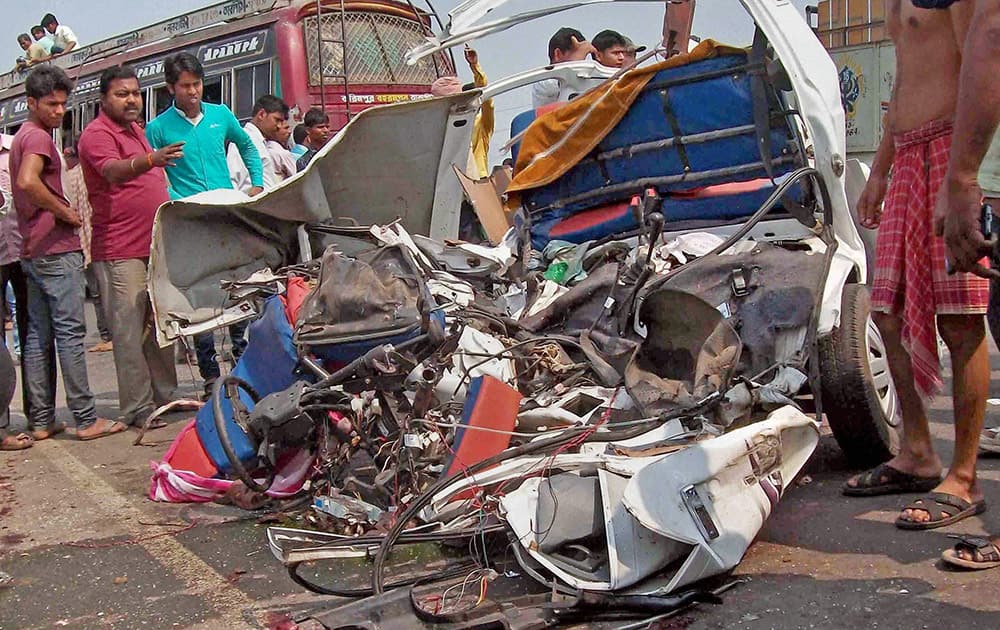 People gather around the wreckage of a car after an accident at National Highway-60 in Birbhum district of West Bengal.