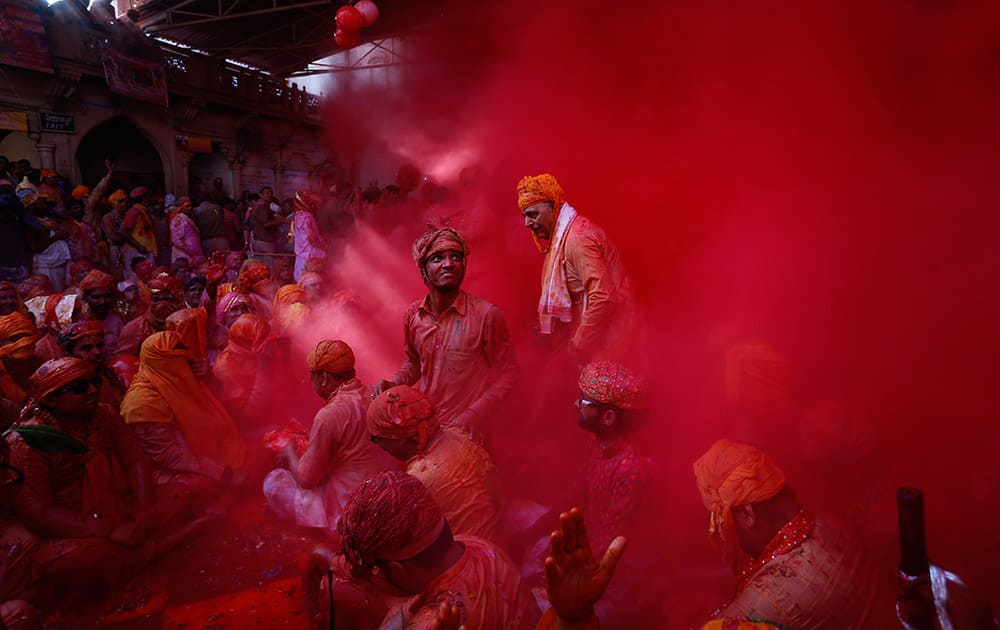 Hindu men from the village of Nandgaon throw colored powder at each other as they play holi at the Ladali or Radha temple before taking out a procession for the Lathmar Holi festival at the legendary hometown of Radha, consort of Hindu God Krishna, in Barsana.