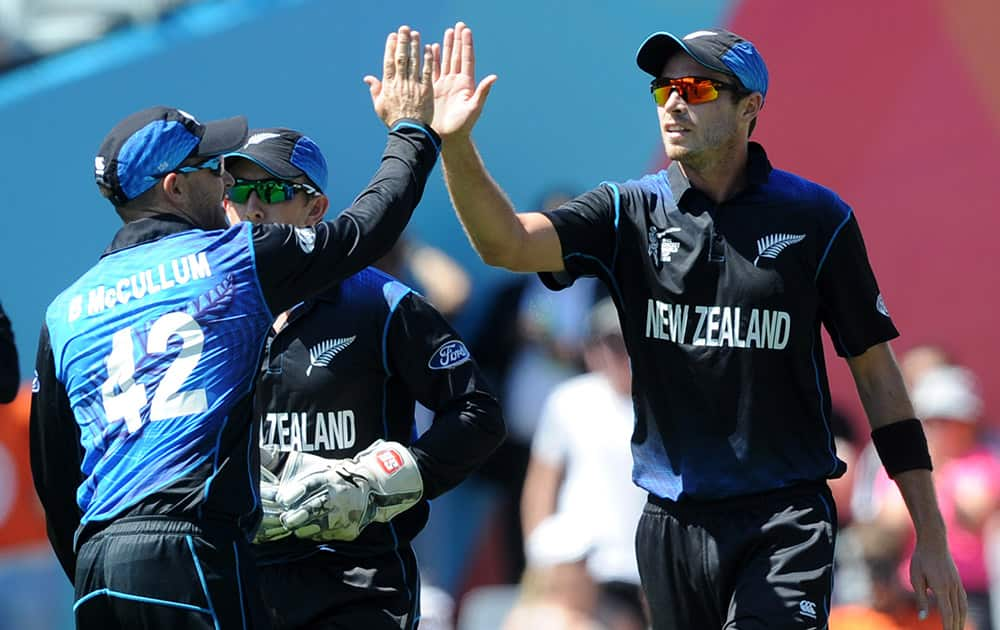 New Zealand's Tim Southee, right, is congratulated by his captain Brendon McCullum after taking a catch to dismiss Australian batsman Shane Watson during their Cricket World Cup match in Auckland.