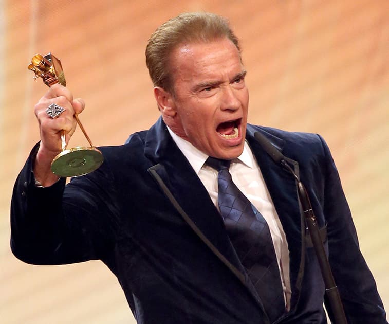 Arnold Schwarzenegger holds a Golden Camera lifetime achievement award during awarding ceremony in Hamburg, northern Germany.