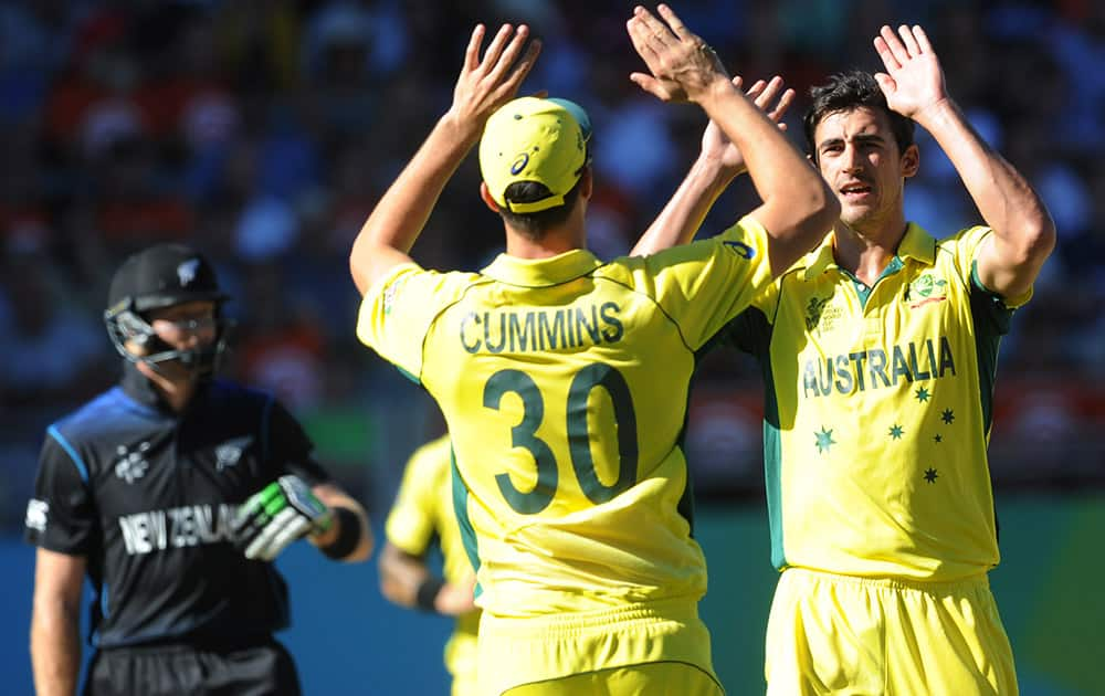 Australia's Mitchell Starc, right, is congratulated by his teammate Patrick Cummins after dismissing New Zealand batsman Martin Guptill, left, during their Cricket World Cup match in Auckland, New Zealand.