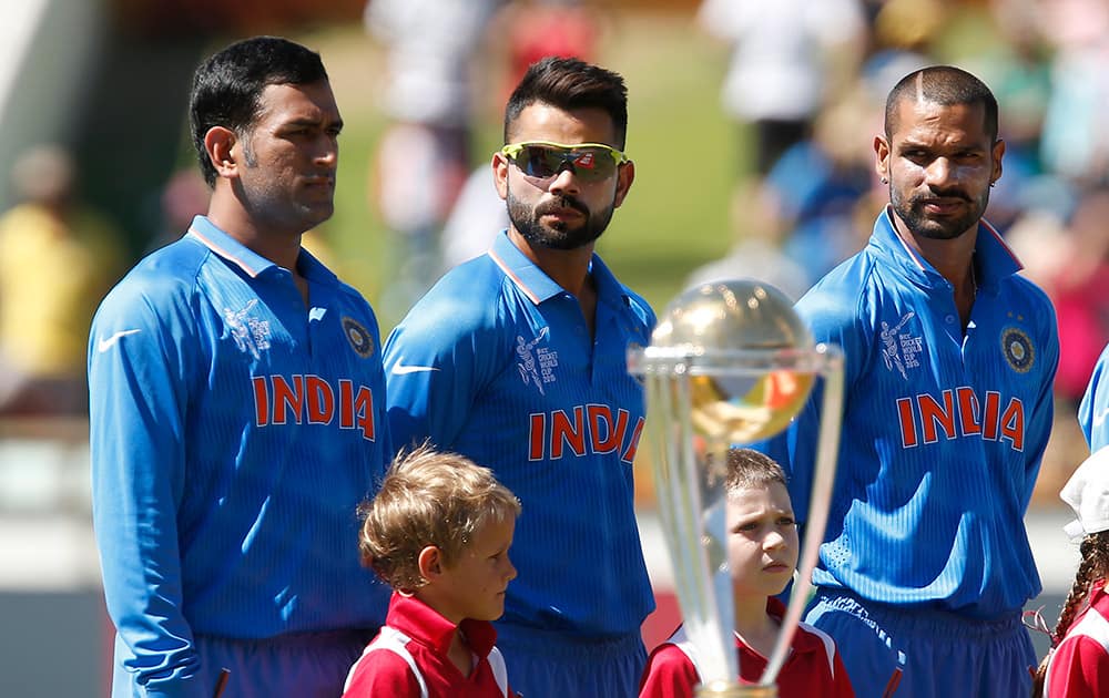 M S Dhoni, Virat Kohli center and Shikhar Dhawan stand behind the ICC World Cup Trophy before their Cricket World Cup Pool B match against The United Arab Emiraits in Perth, Australia.