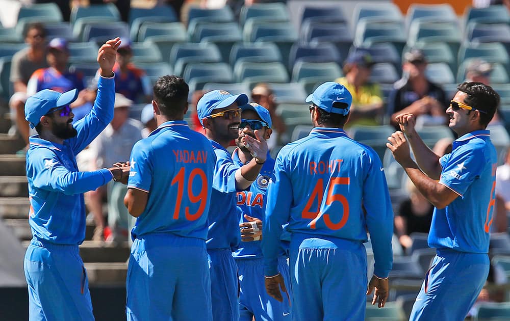 Ravindra Jadeja, congratulates bowler Umesh Yadav, after he took the wicket of United Arab Emirates batsman Andri Raffaelo during their Cricket World Cup Pool B match in Perth, Australia.