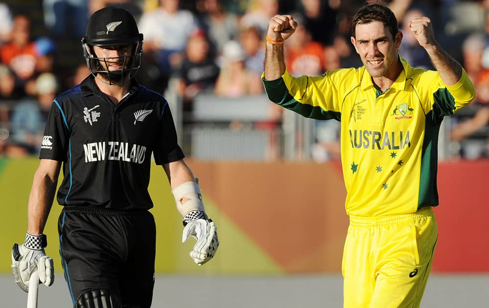 Australia's Glenn Maxwell celebrates after taking the wicket of New Zealand’s Corey Anderson as New Zealand's Kane Williamson, left, watches during their Cricket World Cup match in Auckland, New Zealand.