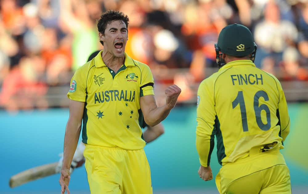 Australian bowler Mitchell Starc, celebrates with teammate Aaron Finch after taking the wicket of New Zealand's Tim Southee during their Cricket World Cup match in Auckland.