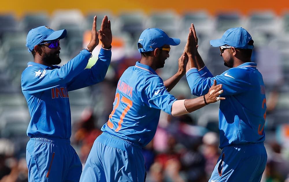 Suresh Raina, celebrates with team mates Ajinkya Rahane and Rohit Sharma after catching out United Arab Emirates batsman Khurram Khan during their Cricket World Cup Pool B match in Perth, Australia.