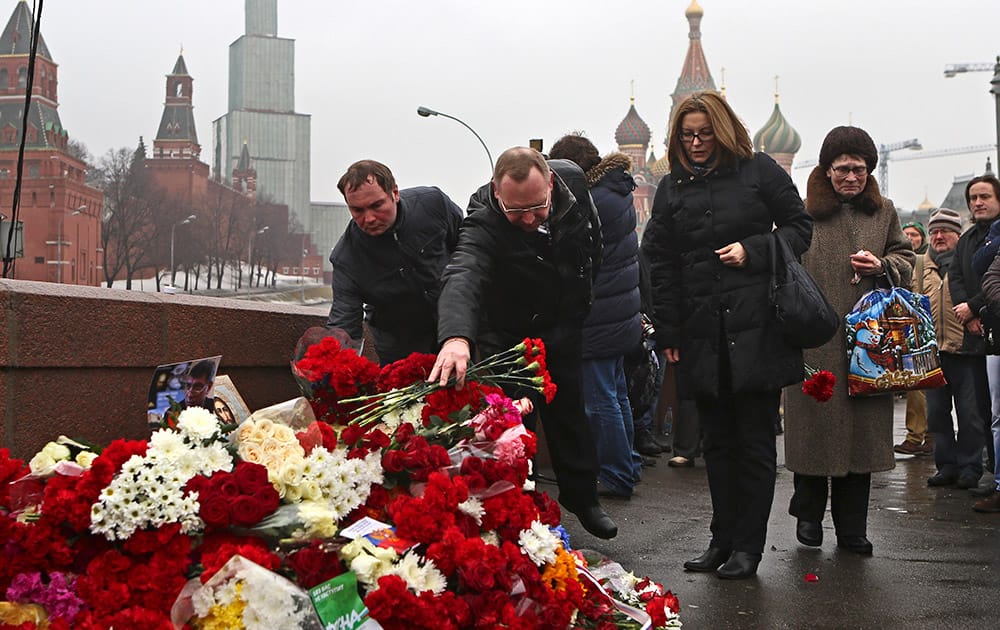 People lays flowers at the place where Boris Nemtsov, a charismatic Russian opposition leader and sharp critic of President Vladimir Putin, was attacked, at Red Square in Moscow, Russia.