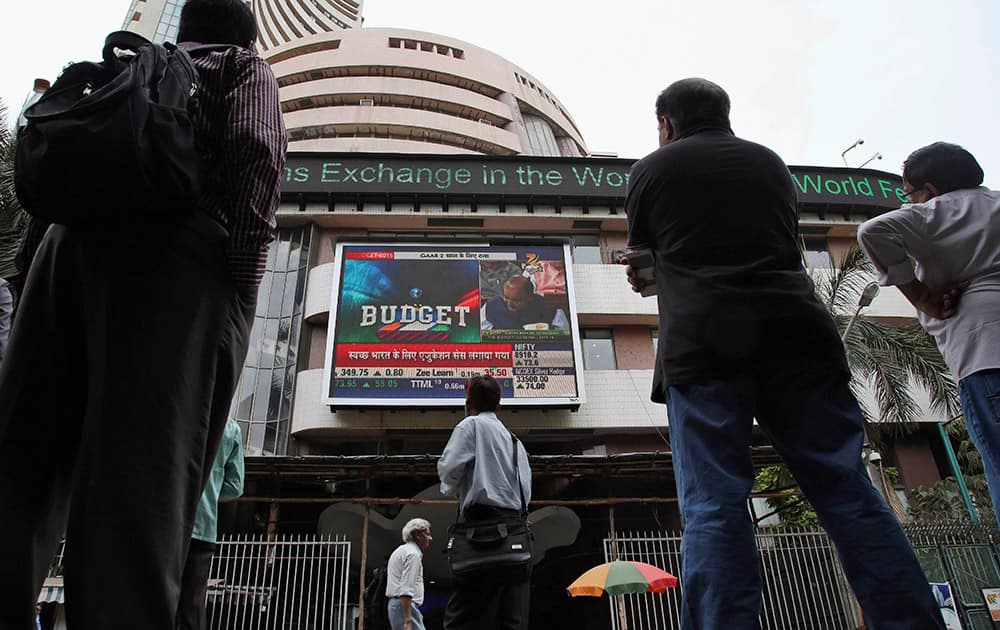 People watch Indian Finance Minister Arun Jaitley make the union budget speech on a television screen outside the Bombay Stock Exchange (BSE) in Mumbai, 