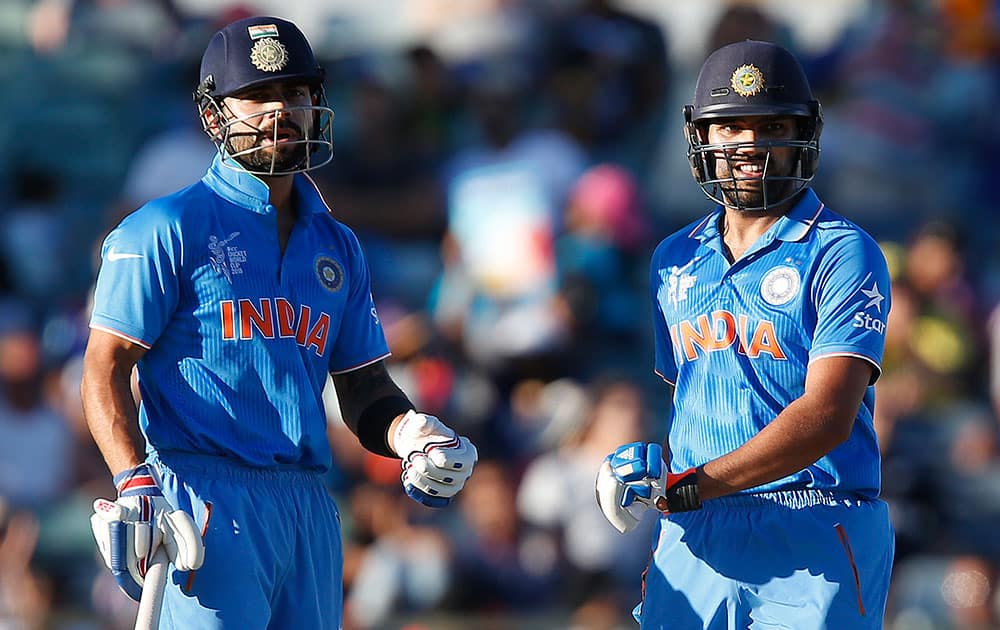 India's Virat Kohli left, and Rohit Sharma chat at mid wicket during their Cricket World Cup Pool B match against the United Arab Emirates in Perth, Australia.