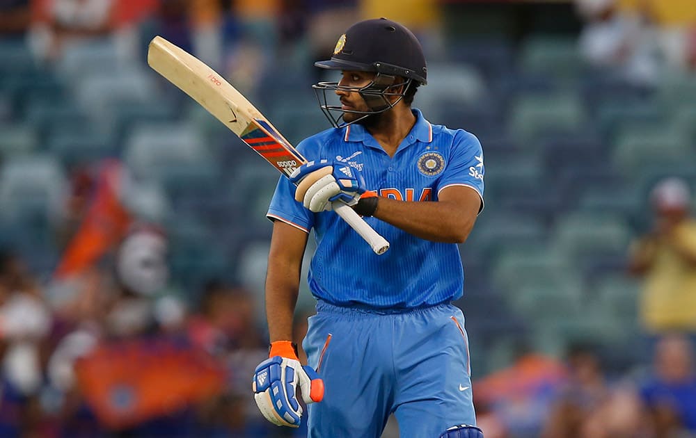 Rohit Sharma raises hit bat after hitting a half century during their Cricket World Cup Pool B match against the United Arab Emirates in Perth, Australia.