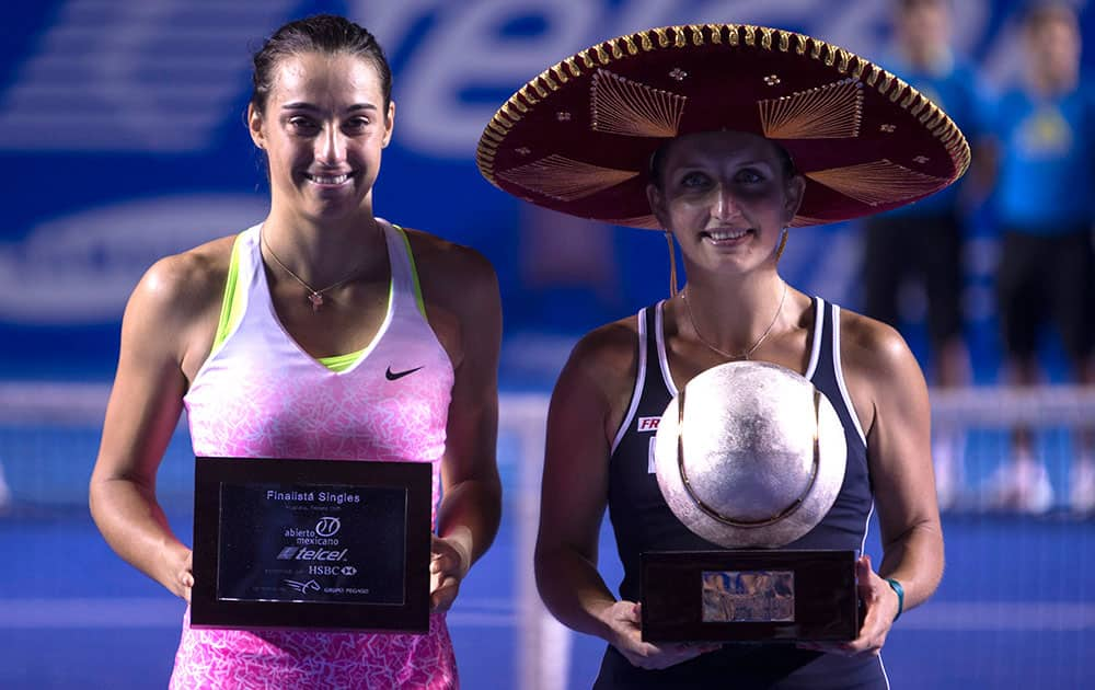 Timea Bacsinszky of Switzerland, right, and Caroline Garcia of France pose with their trophies at the end of the women's singles of the Mexico Open tennis tournament in Acapulco.