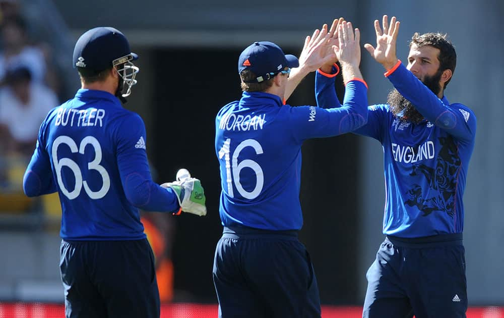 England's Moeen Ali, right, is congratulated by teammates Jos Butler, left, and Eion Morgan after taking the wicket of Sri Lanka's Tillakaratne Dilshan during their Cricket World Cup match in Wellington, New Zealand.