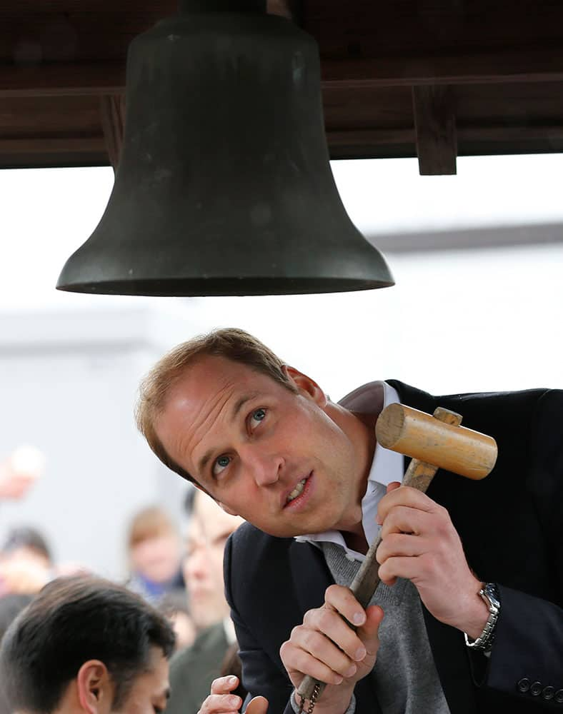 Britain's Prince William looks at Chime of Hope as he rings the bell in a neighborhood destroyed by the March 11, 2011 earthquake and tsunami in Onagawa, Miyagi Prefecture, in northeastern Japan.