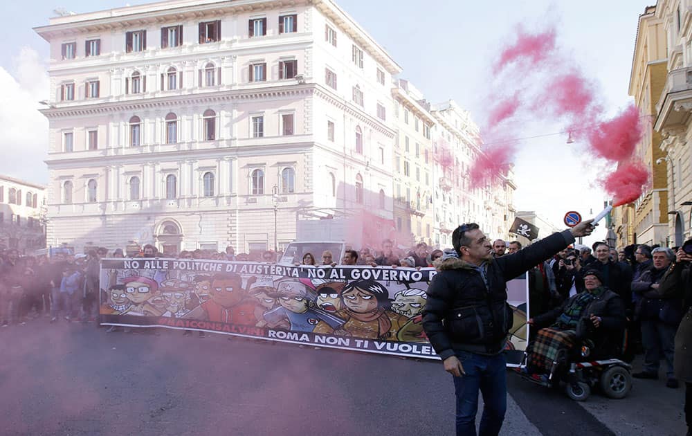 vDemonstrators hold up a banner reading in Italian 