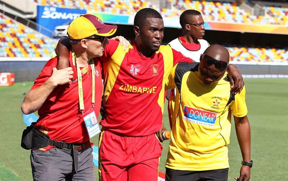 Zimbabwe's Elton Chigumbura, center, is helped off the field after he got injured during the Pool B Cricket World Cup match against Pakistan in Brisbane, Australia.