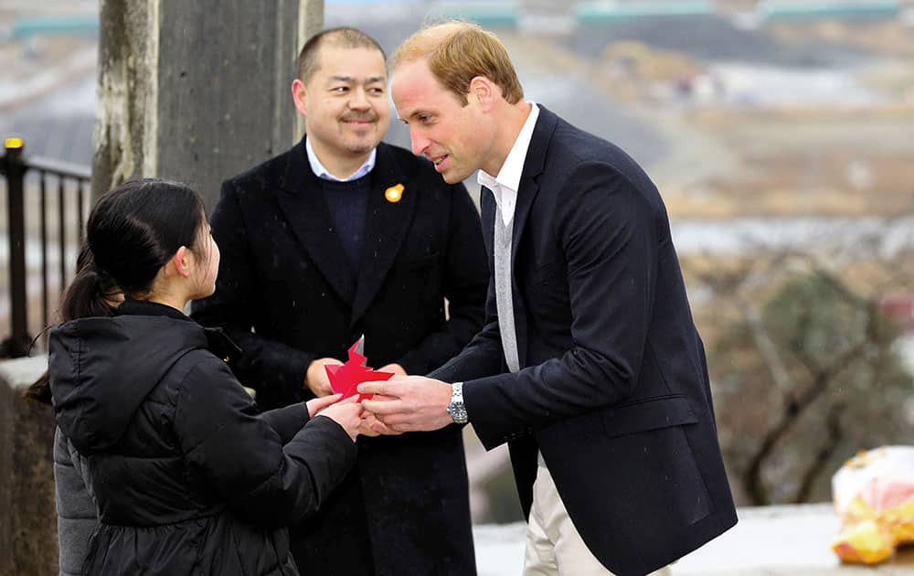 Britain's Prince William receives paper crane from girls as he visits the ravaged waterfront area devastated by the 2011 tsunami at Hiyoriyama Park in Ishinomaki, Miyagi Prefecutre, northeastern Japan.