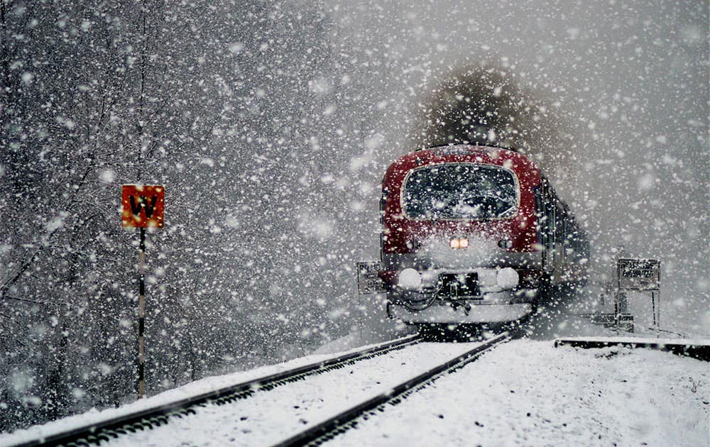 A train moves through snow covered railway track as the region received heavy snowfall, in Anantnag.
