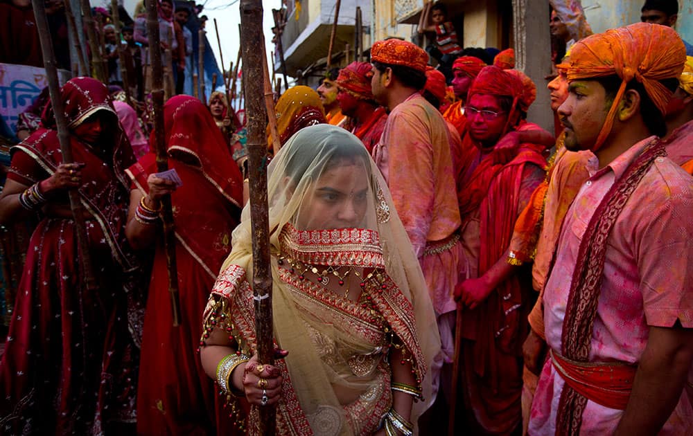 Women from Nandgaon village with their wooden sticks wait for men from Barsana village during Lathmar holi festival celebrations in Nandgaon