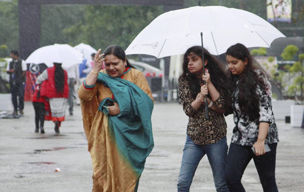 People with their umbrellas as the city received early morning showers, in Gurgaon.