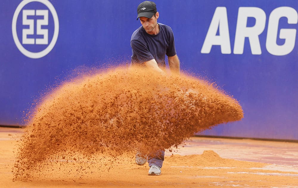 A worker adds dry clay to the court during a rain delay at Argentina's ATP Open final tennis match between Rafael Nadal of Spain and Juan Monaco in Buenos Aires, Argentina.