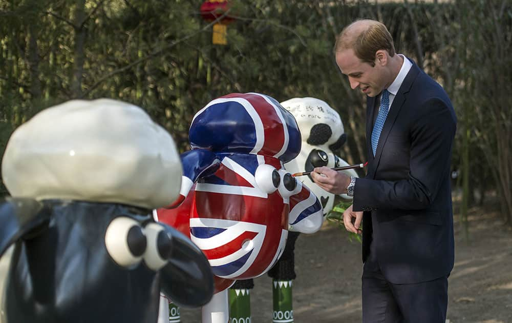 Britain's Prince William paints the eye of Shaun the Sheep at the British Ambassador's official residence in Beijing.