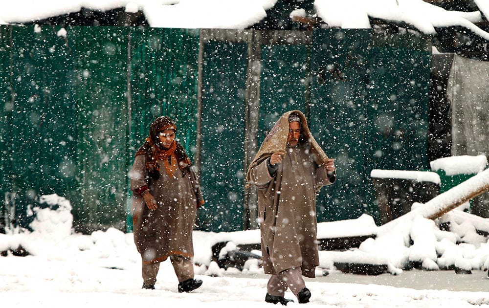 Kashmiri people walk in the snow in Srinagar, India.