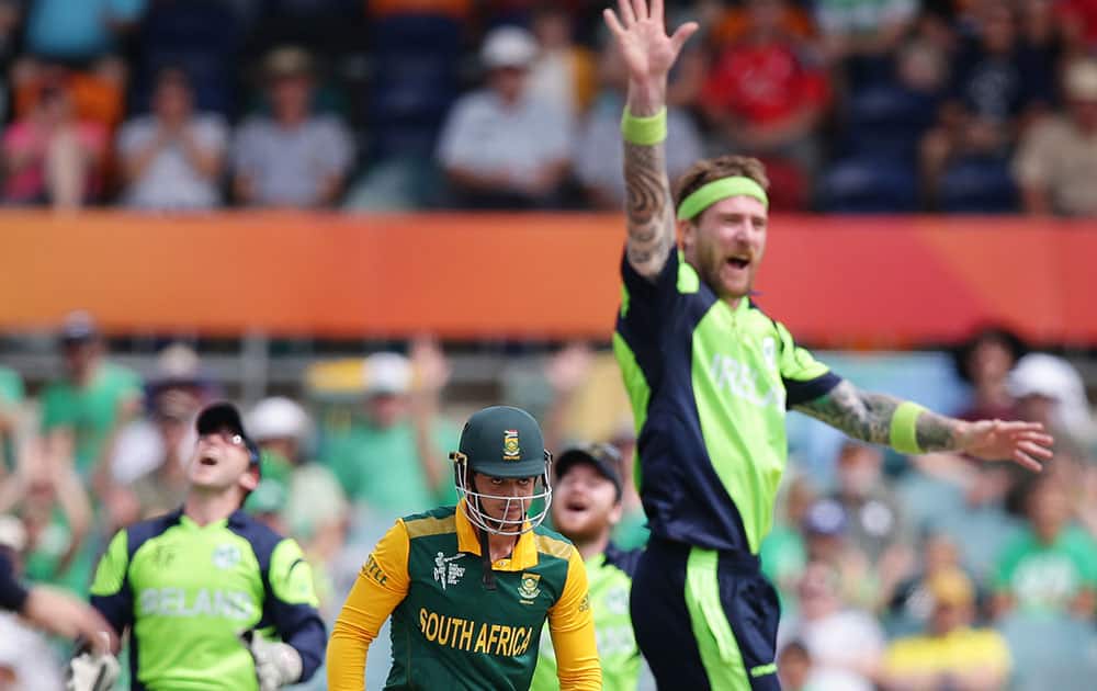 Ireland's John Mooney, right, appeals successfully for the dismissal of South African batsman Quinton De Kock, centre, during their Cricket World Cup Pool B match in Canberra, Australia.