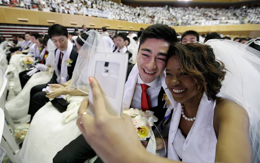 A couple takes a selfie before a mass wedding ceremony at the Cheong Shim Peace World Center in Gapyeong, South Korea. 3,800 couples from more than fifty countries exchanged or reaffirmed marriage vows in the Unification Church's mass wedding arranged by Hak Ja Han Moon, wife of the late Rev. Sun Myung Moon, the controversial founder of the church.