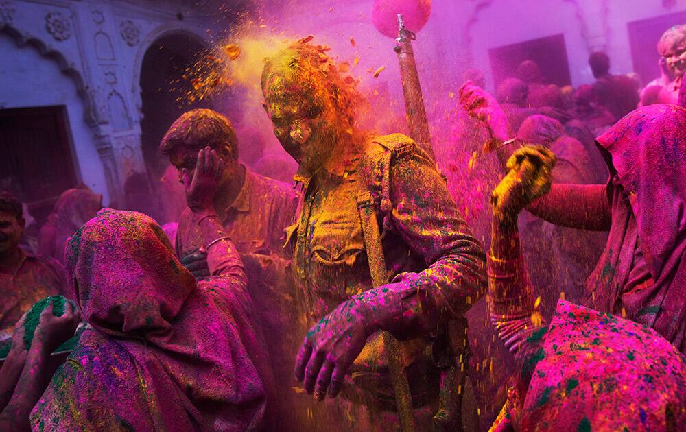 Hindu widows throw colored powder on a policeman as they celebrate Holi, the Hindu festival of colors, at the Meera Sahabhagini Widow Ashram in Vrindavan.