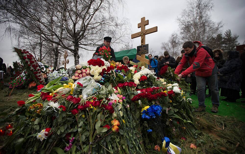 People lay flowers at Boris Nemtsov's grave after a burial ceremony at Troekurovskoye cemetery in Moscow, Russia.
