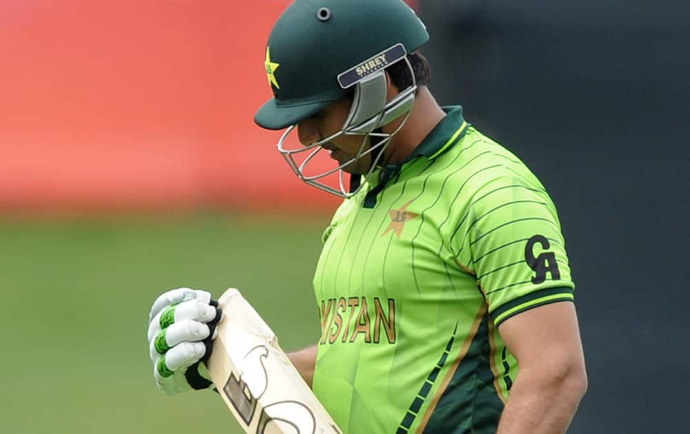 Pakistan's Nasir Jamshed looks at his bat after he was dismissed while batting against the United Arab Emirates during their Cricket World Cup Pool B match in Napier, New Zealand.