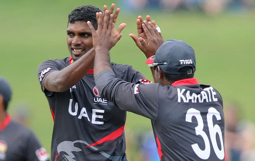 United Arab Emirates K. Karate, right, congratulates teammate Manjula Guruge after taking the wicket of Pakistan's Nasir Jamshed during their Cricket World Cup Pool B match in Napier, New Zealand.