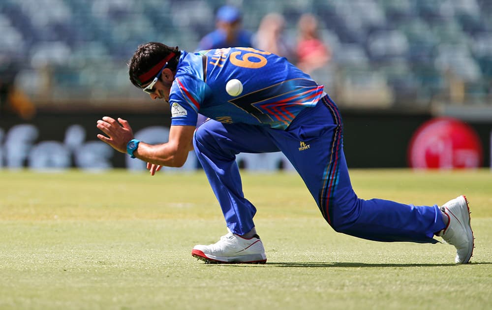 Afghanistan’s Hassan Hamid falls as he fields during their Cricket World Cup Pool A match against Australia in Perth, Australia.