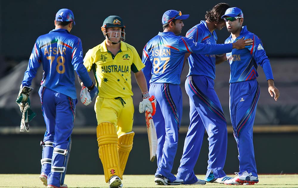 Afghanistan’s players congratulate teammate Mohammad Nabi for the dismissal of Australia's David Warner during their Cricket World Cup Pool A match in Perth, Australia.