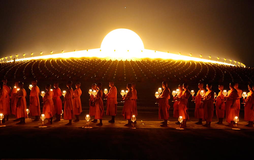 Thai Buddhist monks hold candle light gather at Wat Dhammakaya temple in Pathum Thani province to participate in Makha Bucha Day ceremonies. Makha Bucha, a religious holiday that marks the anniversary of Lord Buddha's mass sermon to the first 1,250 newly ordained monks 2,558 years ago.