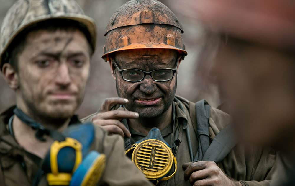 Ukrainian coal miners wait for a bus after exiting the underground of the Zasyadko mine in Donetsk, Ukraine.