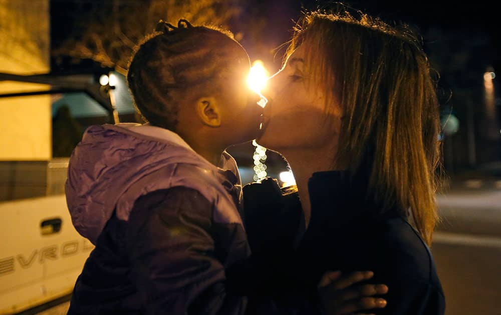 Virginia women's basketball coach Joanne Boyle, right, gets a kiss from her adopted daughter Ngoty, in Charlottesville, Va. 