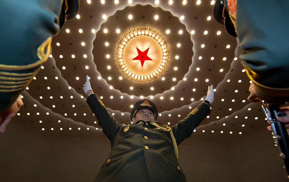 A military band conductor leads during the opening session of the National People's Congress at the Great Hall of the People in Beijing.